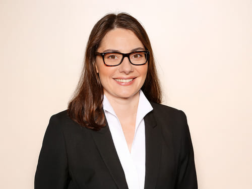 Wamser-Team: Reissmueller Frau N. Reissmüller: Eine Person mit langen Haa-ren trägt einen schwarzen Blazer über einem weißen Hemd.