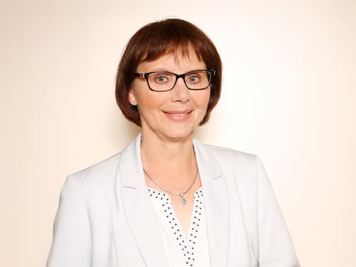 Wamser-Team: Rupprecht-Held Frau C. Rupprecht-Held: Eine Person trägt einen hel-len Blazer über einem gemus-terten Hemd. Der Hintergrund ist schlicht und hell.